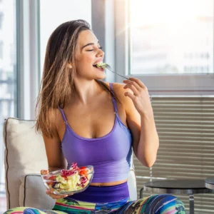 Woman enjoying a bowl of fruit salad.