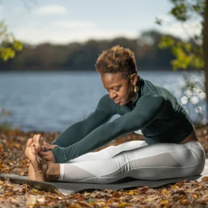 Woman practicing yoga by a lake.